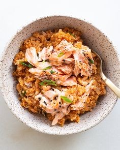 a white plate topped with rice and meat next to an egg on top of it