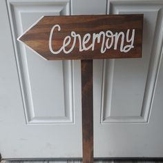 a wooden sign with the word ceremony on it in front of a white door,