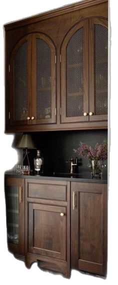 a kitchen with wooden cabinets and black counter tops, along with a white wall behind it