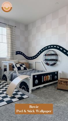 a room with a bed, desk and wallpaper on the walls is decorated in black and white