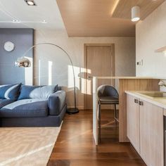 a living room filled with furniture next to a kitchen