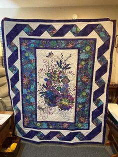 a blue and white quilt with flowers on it