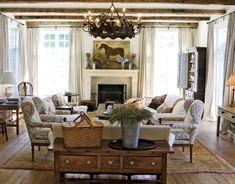 a living room filled with furniture and a fire place in the middle of a room