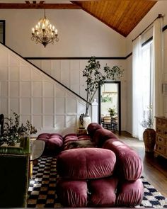 a living room filled with lots of furniture and a chandelier hanging from the ceiling