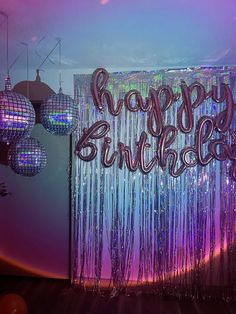 there is a happy birthday sign in front of the disco ball backdrop and chandelier