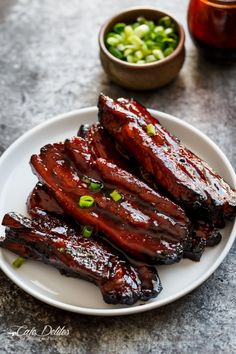 barbecue ribs on a white plate with green onions