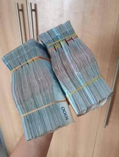 two stacks of money sitting on top of each other in front of a wooden door