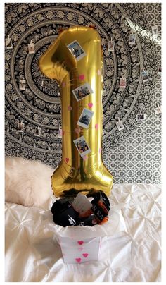 a balloon shaped like the number one sitting on top of a bed with other items