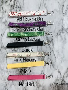 five different colored lanyards with the names of each one on them in black, pink, yellow, and green