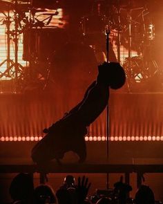 a person standing on one leg in front of a stage