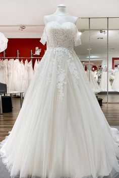 a white wedding dress on display in a store