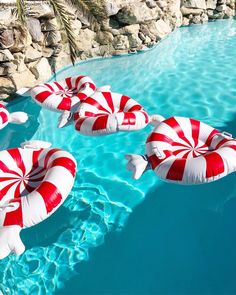 several inflatable candy canes floating on top of a pool with blue water