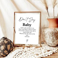 a sign that says don't say baby next to a potted plant and vase