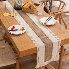 a wooden table topped with plates and bowls filled with food next to a basket of fruit