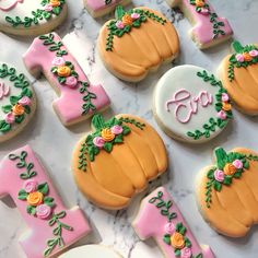 decorated cookies are arranged in the shape of numbers and pumpkins on a marble surface