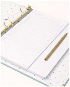 a notepad and pen sitting on top of a binder next to a pair of scissors