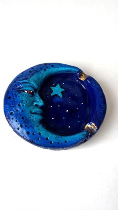 a small blue dish with a star on the top and a moon in the middle