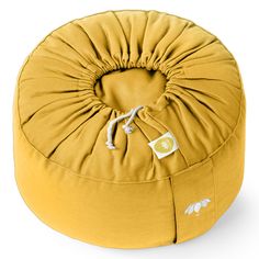 a round yellow cushion with white flowers on it and a drawstring around the bottom