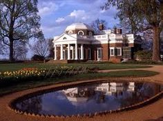 a large house with a pond in front of it