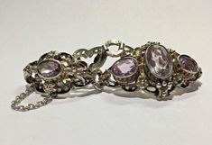 "Antique 925 Silver & Gold Gilt Enamel & Oval Purple Amethyst Bracelet with Safety Chain Metal: 935 silver (stamped) Weight: 29.2 grams Stones: (1) 15 x 10mm oval amethyst (4) 10 x 8mm oval amethyst Size: 7\" long including clasp, 2 1/2\" long safety chain Hallmarked: 935 This is an estate piece in good condition (slight wear on amethyst and missing some enamel). It is in its original worn state and can be re-polished upon request. Please see pictures for reference." Formal Silver Amethyst Bracelet, Sterling Silver Amethyst Bracelet For Anniversary, Sterling Silver Oval Gemstone Bracelet, Sterling Silver Oval Bracelet With Gemstone, Oval Sterling Silver Bracelet With Gemstone, Safety Chain, Amethyst Bracelet, Wedding Bracelet, Silver And Gold