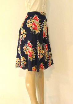 "Vintage multi color floral on navy blue background skirt from Ralph Lauren; lightweight, super soft and airy knee length feminine skirt features full, flouncy bottom, side pocket, and button and hook and eye closure. Unlined. Approximate Measurements: - Waist: 30.5\"; Hips: Up to 48\"; Length: 24.5\" - Labeled a Size 14 Pure rayon designer skirt, circa 1980s, is in excellent vintage condition. As with all vintage items, may have imperfections consistent with age, though none noted. Enjoy! *Inte Flowy Floral Print Rayon Skirt, Floral Print Knee-length Bottoms For Beach, Summer Flowy A-line Bottoms, Casual A-line Beach Skirt, Summer Knee-length Vacation Skirt, Summer Vacation Knee-length Skirt, Summer Knee-length Skirt For Vacation, Rayon Floral Print Skirt For Day Out, Casual Rayon Flared Skirt