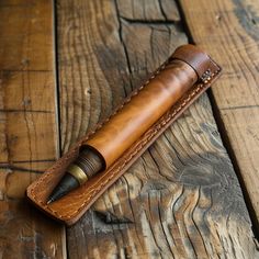 a leather pen case sitting on top of a wooden table