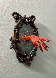 an orange hand is sticking out of a mirror