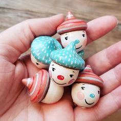 small wooden toy figures in the palm of someone's hand