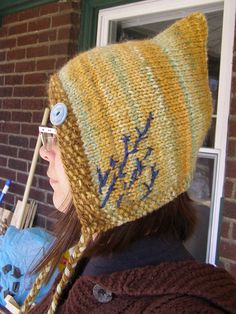 a woman wearing a knitted hat with buttons on it