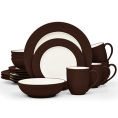 the brown and white dishes are stacked on top of each other, with cups in front