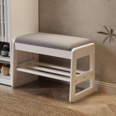 a white bench with a cushion on it in front of a radiator and wall