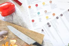 a cutting board topped with sliced up oranges and a knife next to some paper