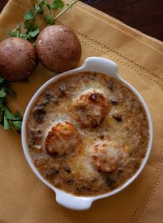 this is a bowl of soup with shrimp and potatoes in it on a yellow table cloth