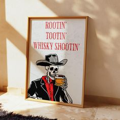 a framed poster with a skeleton wearing a cowboy hat and holding a drink