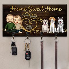 two dogs and three people are hanging on the wall with key holders in front of them