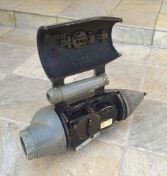 an old camera sitting on top of a tile floor