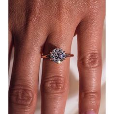 a woman's hand with an engagement ring on her finger and the diamond in the middle