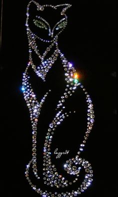 a string of lights hanging from the side of a building in front of a black background