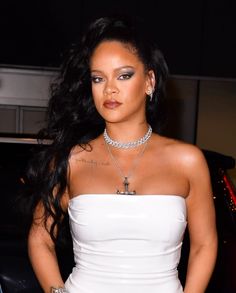 a woman in white dress standing next to a car with her hands on her hips