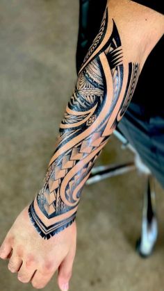 a man's arm with an intricate tattoo design on the forearm and hand,