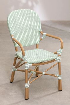 a green and white chair sitting on top of a cement floor