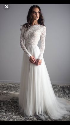 a woman in a long sleeved wedding dress