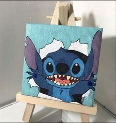 an easel with a painting of stitching stitched into the shape of a cartoon character