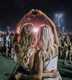 two women standing next to each other in front of a crowd