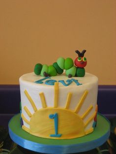 a cake with the very hungry caterpillar on it's top is sitting on a table