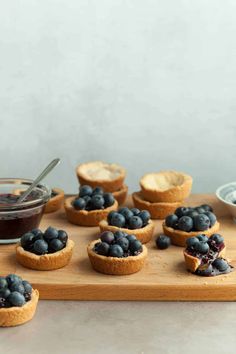 mini blueberry pies are arranged on a cutting board and ready to be eaten