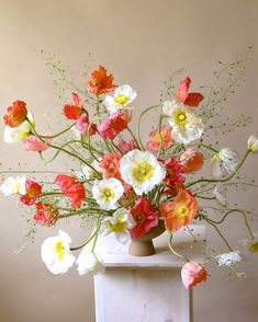 a vase filled with lots of different colored flowers