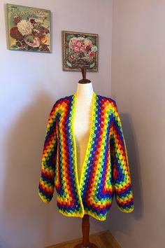 a colorful crocheted jacket sitting on top of a mannequin