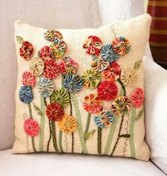 an embroidered pillow with colorful flowers on it