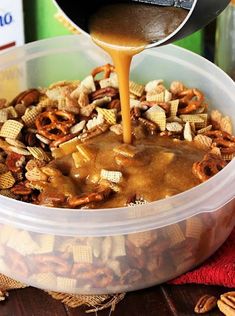 a container filled with cheetos and nuts being poured into it